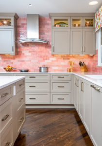 kitchen with white cabinets and pink tile