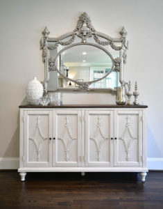 silver mirror above white vanity
